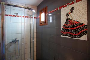 a bathroom with a shower with a painting of a woman at Seranides Boutique Hotel in Kato Gatzea +60 photos