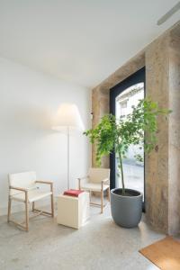 a living room with a plant in a large pot at Porto Real Hotel in Finisterre