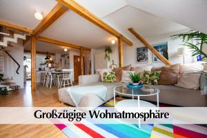 ein Wohnzimmer mit einem Sofa und einem Tisch in der Unterkunft Helles 80m2 Maisonette-Loft mit Balkon, Kingsize Bett, Smart-TV, etc in Erfurt