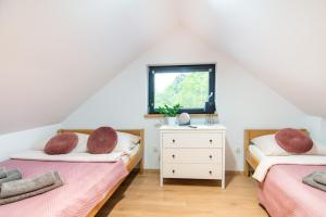 a attic bedroom with two beds and a window at Domki na odludziu in Kazimierz Dolny