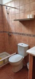 uma casa de banho com um WC, um chuveiro e um lavatório. em Habitación matrimonial en un bajo baño compartido Areas compartidas em Abades