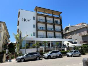 tres autos estacionados en un estacionamiento frente a un edificio en Hotel Costa Verde en Pineto