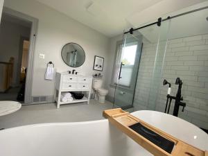 bagno con vasca, lavandino e specchio di Thunderbird Farm a Kawartha Lakes