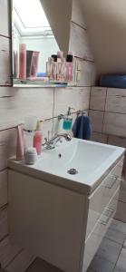 W łazience znajduje się biała umywalka i lustro. w obiekcie Gandelinka Park Kędrzyno 