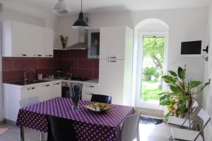 a kitchen with a table with a purple table cloth at Appartamento Le Tre Palme in Frigintini