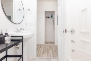 een witte badkamer met een wastafel en een spiegel bij Home Downtown Miami - Wynwood Area & Port - Art District near Beach in Miami