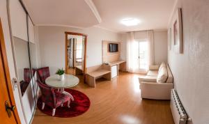 新普拉塔的住宿－Hotel Prata Villaggio，客厅配有桌子和沙发