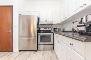 a kitchen with stainless steel appliances and white cabinets at Home Downtown Miami - Wynwood Area & Port - Art District near Beach in Miami