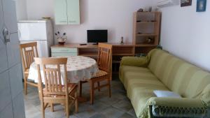 a living room with a couch and a table and a desk at Apartman Val in Rogoznica