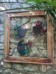 a frame with four glass plates on a stone wall at HeArt of Old Town Guesthouse in Podgorica