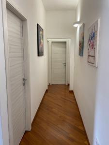 a hallway with white walls and a wooden floor at Max's Apartment in Palermo