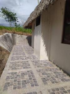 un bâtiment avec une passerelle en carrelage à côté d'une maison dans l'établissement Agradable casa de campo con estacionamiento, à Olón