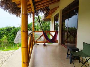 - une terrasse couverte avec un hamac dans une maison dans l'établissement Agradable casa de campo con estacionamiento, à Olón