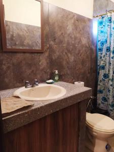 La salle de bains est pourvue d'un lavabo et de toilettes. dans l'établissement Agradable casa de campo con estacionamiento, à Olón