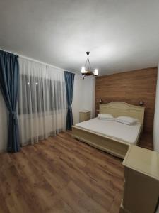 カリマネシュティにあるPensiunea Iasmina si Pescarulのベッドルーム(大型ベッド1台、青いカーテン付)
