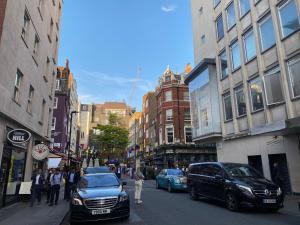 a busy city street with cars parked on the street at Prime Location Apartment - Heart of London in London