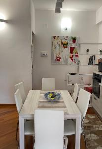 a dining room with a table and white chairs at Max's Apartment in Palermo