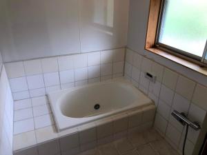 a white tub in a bathroom with a window at BEACH HOUSE OHAMA - Vacation STAY 76214v in Kuranomoto