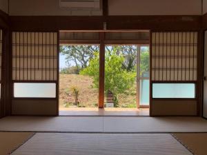 BEACH HOUSE OHAMA - Vacation STAY 76214v في Kuranomoto: باب مفتوح لغرفة مطلة