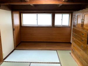 BEACH HOUSE OHAMA - Vacation STAY 76214v في Kuranomoto: غرفة فارغة مع نافذة وخزانة