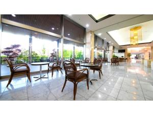 - une salle à manger avec des tables, des chaises et des fenêtres dans l'établissement Hotel Satsukien - Vacation STAY 75958v, à Kanoya