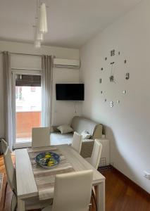 a dining room with a table with chairs and a tv at Max's Apartment in Palermo