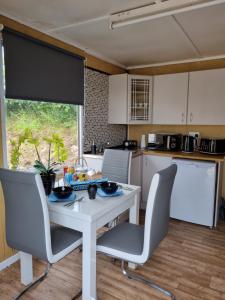 kuchnia z białym stołem i krzesłami w kuchni w obiekcie Firbog Nook w mieście Antrim