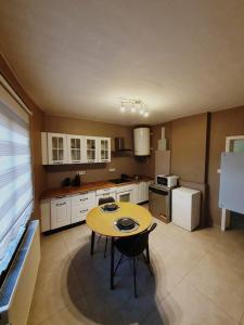 a kitchen with a yellow table and chairs in it at MAT FLAT - 20 minutes à pieds des Ardentes ou 4 minutes en voiture in Liège