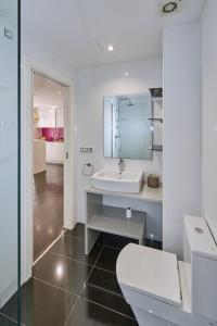 a white bathroom with a toilet and a sink at Galera51 by Serendipia Turismo in A Coruña