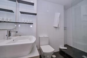 Baño blanco con lavabo y aseo en Galera51 by Serendipia Turismo en A Coruña