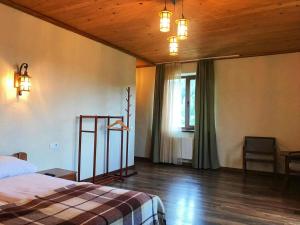 - une chambre avec un lit, une fenêtre et un plafond en bois dans l'établissement Рудий Лис, à Skhidnitsa