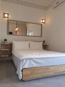 1 dormitorio con 1 cama grande y espejo en Premium apartment with parking, en Ciampino