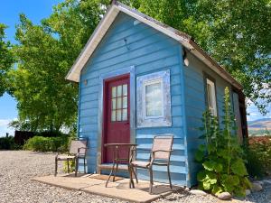 una casa blu con sedie e un tavolo di fronte di Violet Cottage at Zenzen Gardens a Paonia