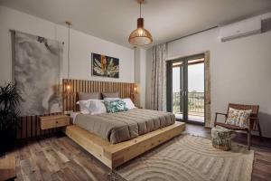 Villa Arianna, close to the beach! في كالاماكي: غرفة نوم بسرير مع اطار خشبي ونافذة