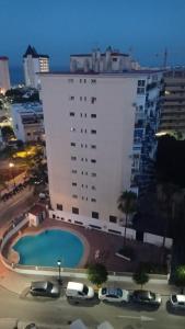 un gran edificio blanco con una piscina frente a él en Fun-sun, en Fuengirola