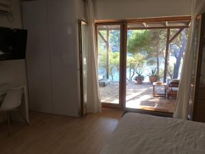 um quarto com uma cama e uma porta de vidro deslizante em Apartment by the sea Žirje with private heated hydromassage pool em Zirje