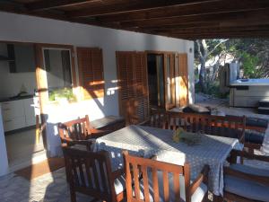 een eetkamer met een tafel en houten stoelen bij Apartment by the sea Žirje with private heated hydromassage pool in Žirje