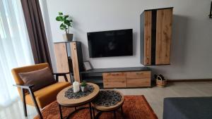 a living room with a table and a tv at Apartman Orange in Bugojno