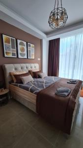 a large bed in a bedroom with a chandelier at Apartman Orange in Bugojno