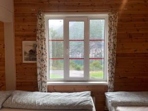 a bedroom with a window in a log cabin at Fjordshelter dorm in Tyssedal