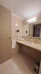 La salle de bains est pourvue d'un lavabo et d'un miroir. dans l'établissement Hotel Del Comahue, à Neuquén