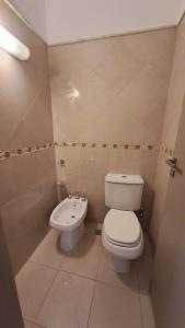 a bathroom with a toilet and a sink at Hotel Del Comahue in Neuquén