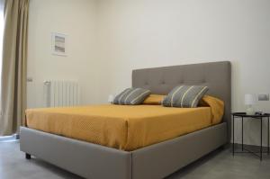 1 dormitorio con 1 cama grande con manta amarilla en La Puteca, en Nápoles