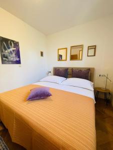 Un dormitorio con una cama grande con una almohada morada. en Peace Sea View Apartment, en Makarska
