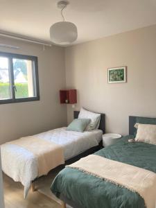 1 dormitorio con 2 camas y ventana en GITE DU GULF STREAM, en Saint-Quay-Portrieux