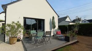 un patio con sillas y una mesa en una casa en GITE DU GULF STREAM, en Saint-Quay-Portrieux