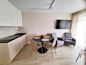 a kitchen and living room with a table and chairs at Giżyckie Lato in Giżycko
