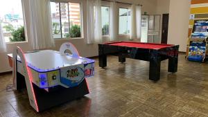 una sala de juegos con mesa de ping pong y mesa de ping pong en Foz Presidente Comfort Hotel en Foz de Iguazú