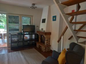 a living room with a staircase and a television at Hegyi Nyaraló Balatonszemes in Balatonszemes
