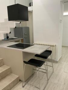 a kitchen with a counter and two stools at a table at Loft con 2 recámaras y 2 baños in Madrid +15 photos